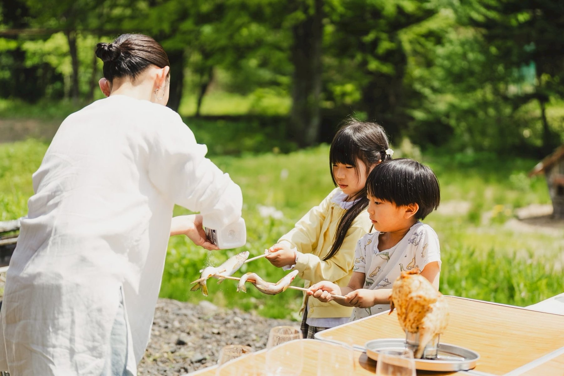 鮎に塩を振る親子